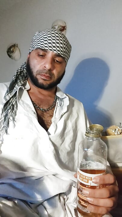 Брудний джанкбро, одягнений в афганський одяг, пісяють у шкарпетках і п'ють