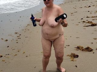 Feliz esposa bailando desnuda en una playa nudista en florida