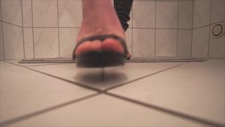 Walking on black sandal heels in bathroom with footjob