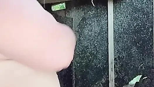 I'm watching a curvy girl wash herself in the street.