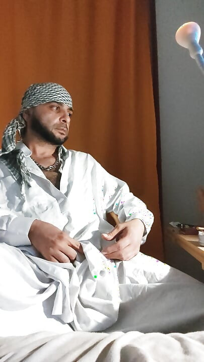 Брудний джанкбро, одягнений в афганський одяг, пісяють у шкарпетках і п'ють