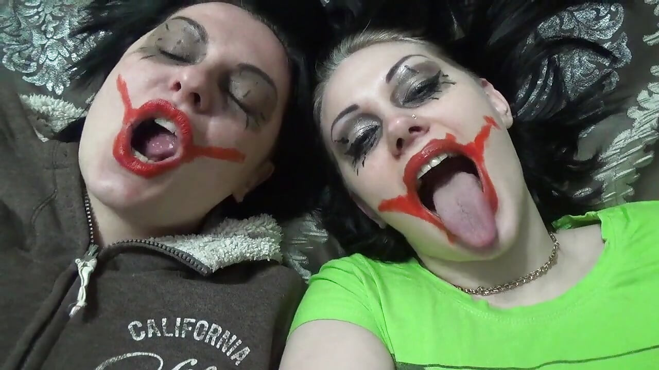 Duas meninas loucas de palhaço balançam você acima de suas bocas famintas antes de brigar por quem vai te comer vivo