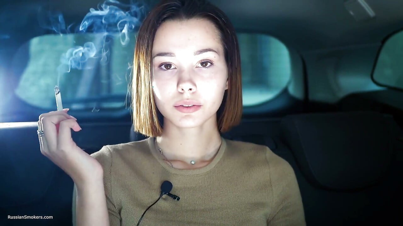 섹시한 러시아 여자가 담배를 피우는 자연스러운 장면
