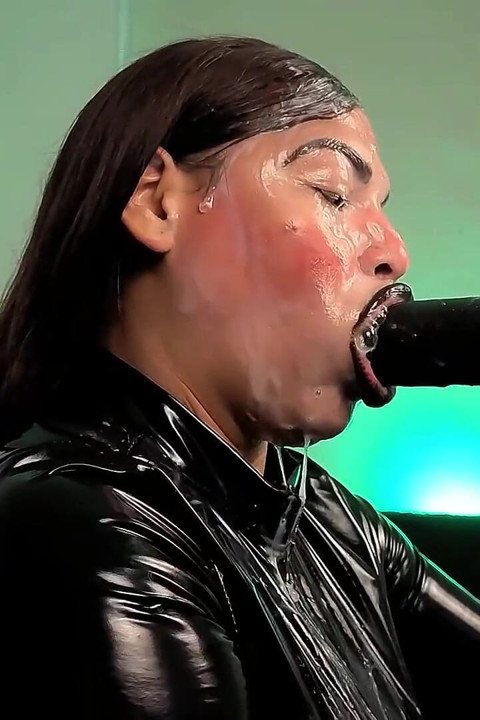 Egy latexbe, latex kesztyűbe, latex öltönybe és fekete ajkakba öltözött démon érzékien szopja a farkadat, nyálat és spermát köp rám