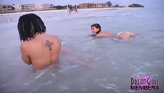 Üç ateşli kız halka açık bir plajda sevişiyor ve üstsüz oluyor