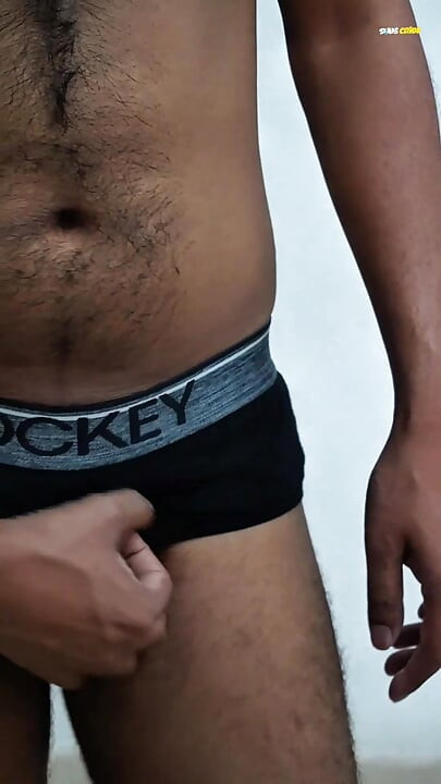Young man wearing black underwear is dancing cock while holding his groin area.