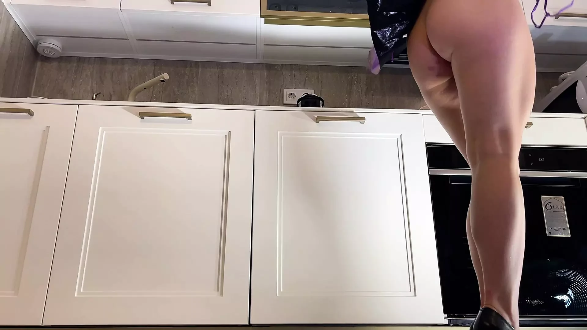 Incredibilmente bella ragazza raver naturale in una super minigonna e un perizoma in cucina prepara il caffè