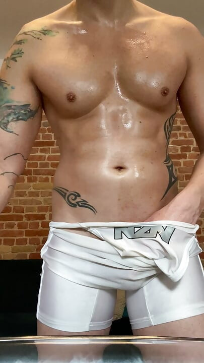 Smooth jock in singlet rubs his thick veiny cock and cums