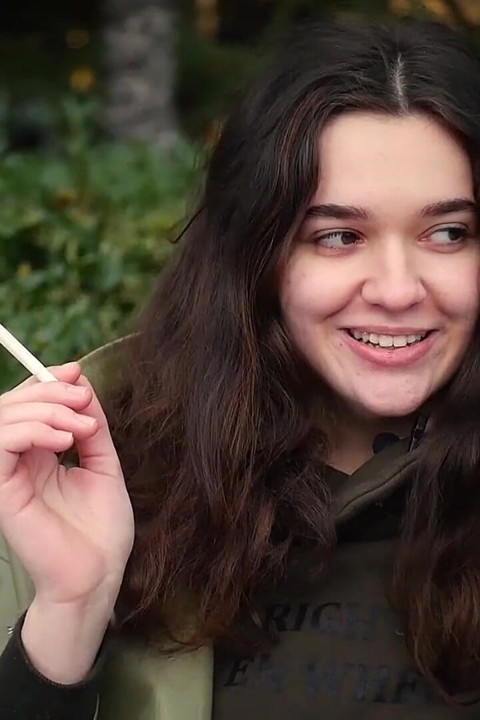 Jovem morena está dando um passeio sem pressa com cigarro Allwhite de 120mm