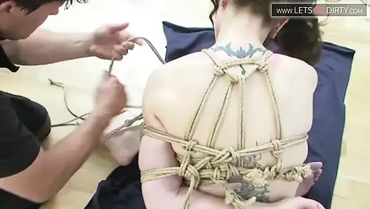 Blonde girl gets hands and legs tied together on the floor