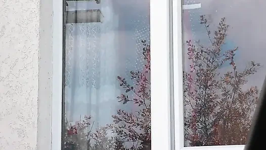 Naked in public. Taxi driver watches from car as woman in robe without panties and bra in stockings washes an apartment window