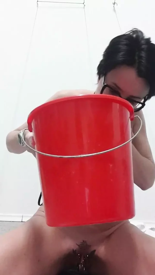 Milf Julie sits on bucket and squirts