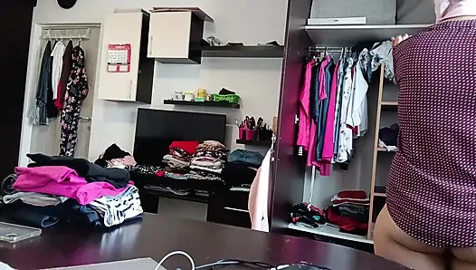 Жена развлекается примеряя одежду и разрезая ее в любительском видео.