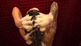 Gadis keramas rambut dengan banyak busa di kamar mandi