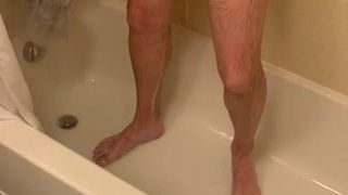 Un homme prend une douche et caresse pendant que sa femme regarde