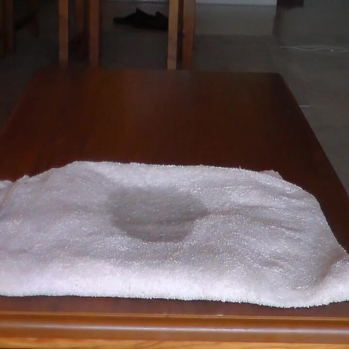 John se jako popiša po ručniku na stolu