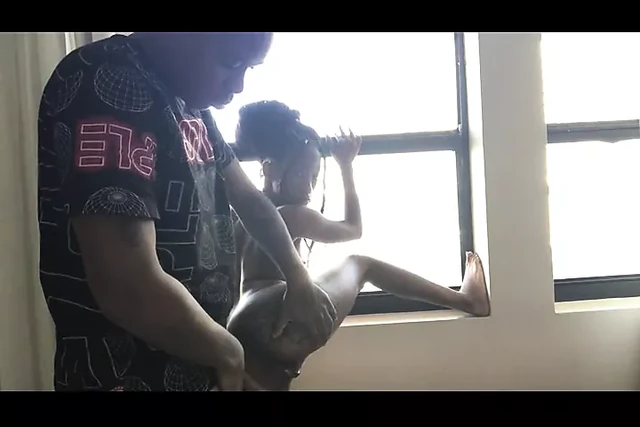 Young black guy doggystyle standing at the window