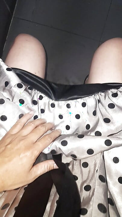 Crossdresser nosi satensku svilenu haljinu na točkice sa svilenkastom podstavom