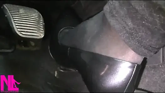 Menyadarkan dan mengemudi dengan stoking hitam dan sepatu hak tinggi abu-abu