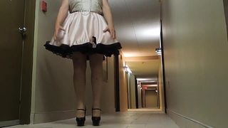 Sissy Ray in roze mietje jurk in hotel gang