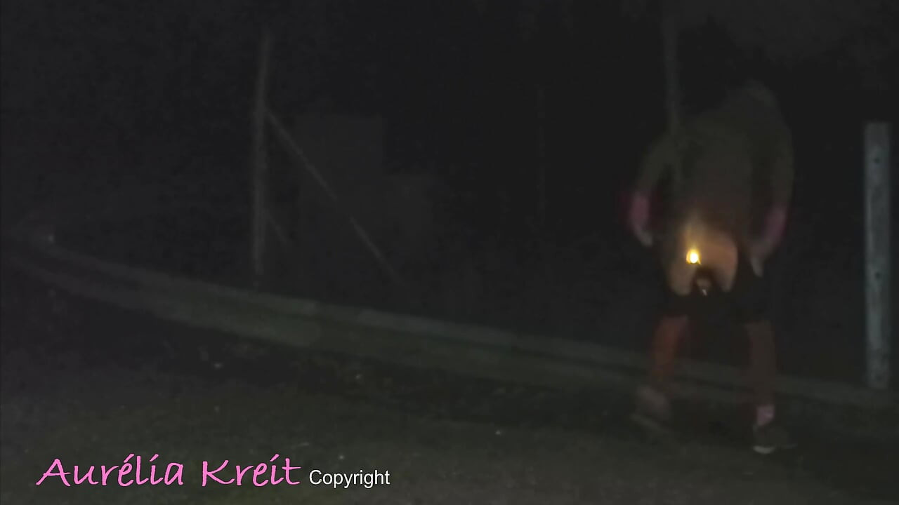 Exhibition at night in safety access off the A7 motorway. lighting anal plug and caged cock