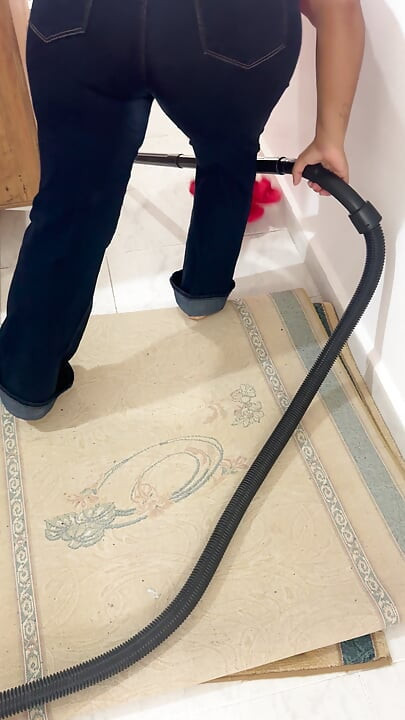 Curvy woman cleaning the house in trousers