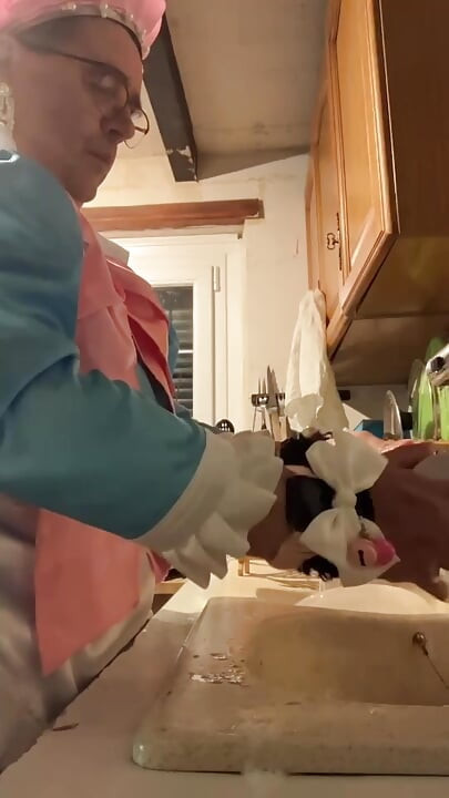 In a blue maid's outfit with pink bows to do the dishes.