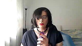 Com tesão, milf travesti simula dar um boquete no parceiro na webcam enquanto brinca com um vibrador na boca