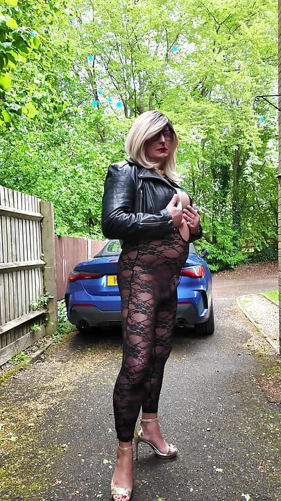 Crossdresser kellycd2022 i svart skinnjakke og blonde catsuit og hæler