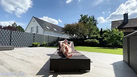 Ateşli orta yaşlı seksi kadın terasta seksi vücudunu şımartıyor ve kendini yağlıyor