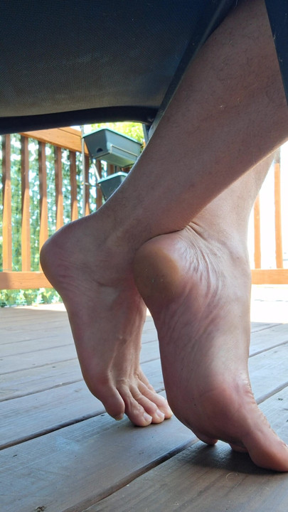 Sneak shot of my feet soles toes barefoot under a chair