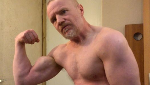 Gespierde papa bodybuilder buigt spieren in sportschoolvest, stript dan naakt en trekt zijn grote pik af!