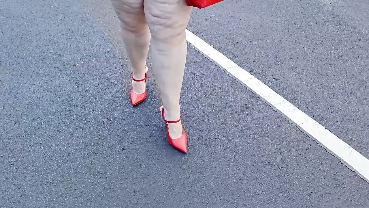 Beautiful woman walking outdoors in public parking lot showing off for strangers