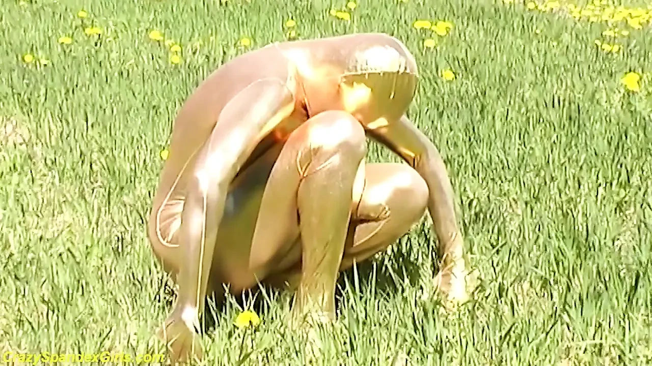 Sexy ebony babe in skintight golden spandex catsuit posing outdoor