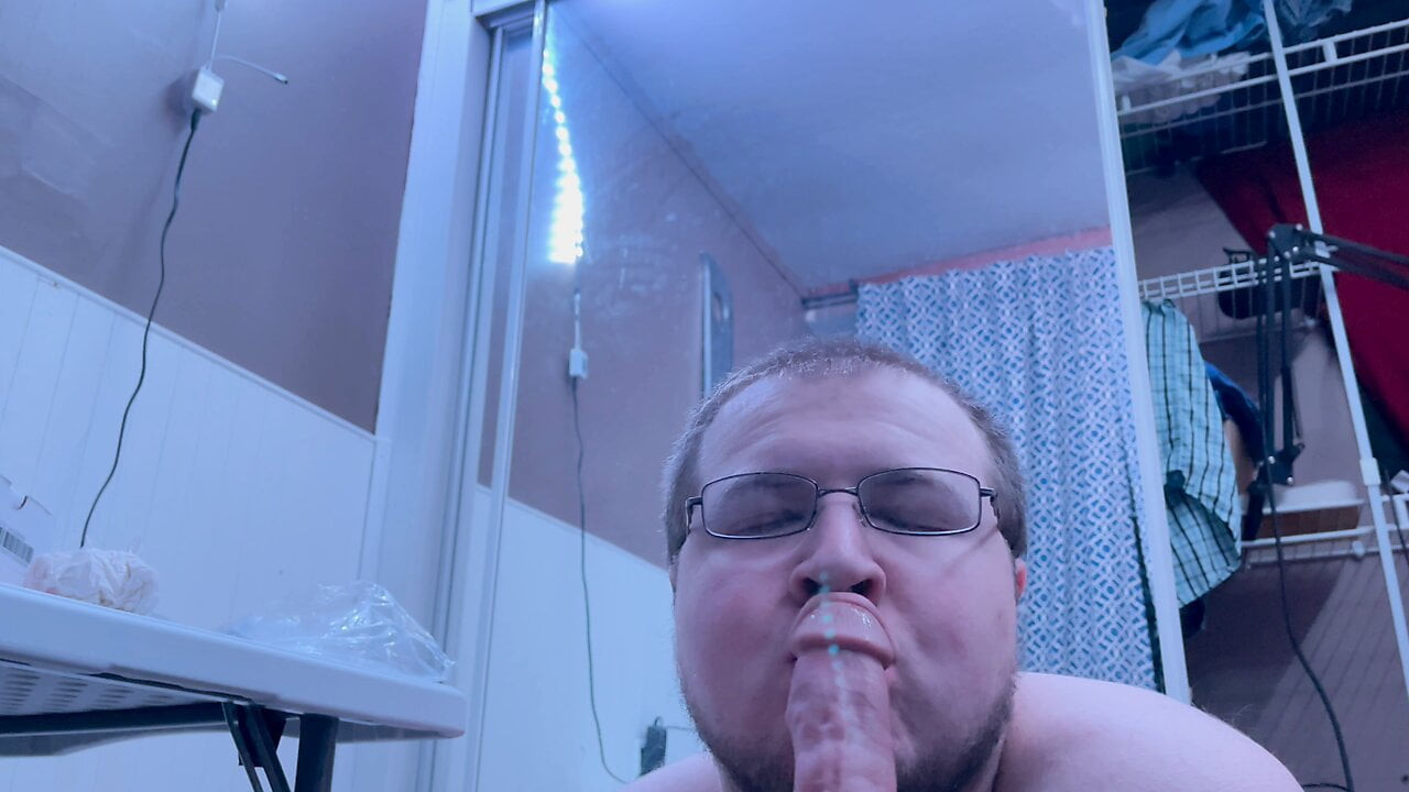 Chubby gay guy practices oral on big black dildo