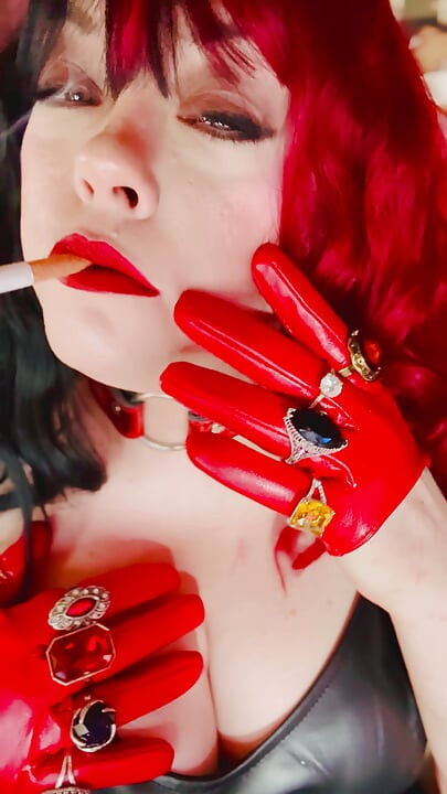 Mặc váy da, găng tay & trang sức Miss Tina Snua hút một điếu thuốc