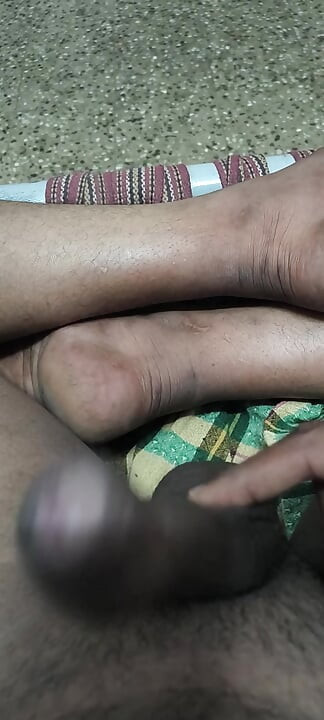 An Indian man is giving himself a massage in his bedroom.