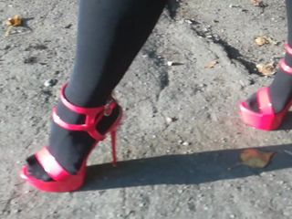 Bayan l seksi kırmızı topuklu ayakkabılarla yürüyor.