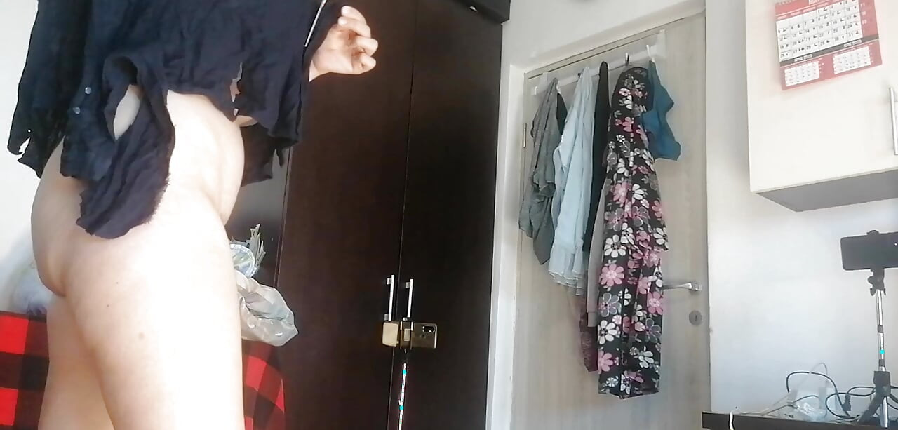 Amatör fru dansar naken hemma. Amatörkvinna har kul att prova kläder och skära dem.