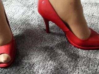 Femme modèle dans les talons peep toe rouges d&#39;une autre femme