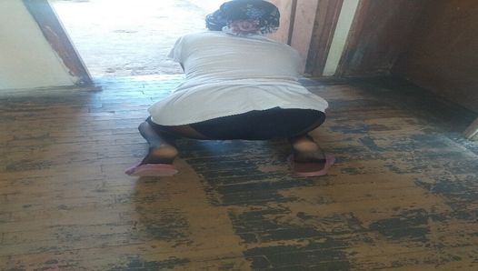 Mujer en hijab limpia el piso de la casa del pueblo