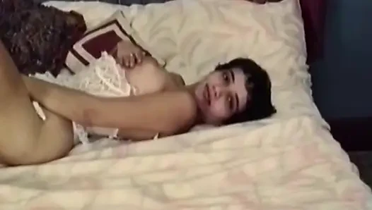 Esmer kadın yatakta soyunuyor ve soyunuyor