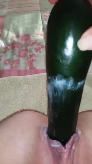 Girl fucking herself with a cucumber