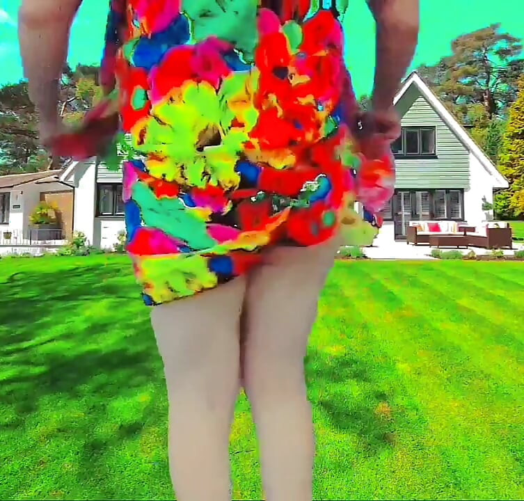 Playful femboy teasing with skirt in windy street