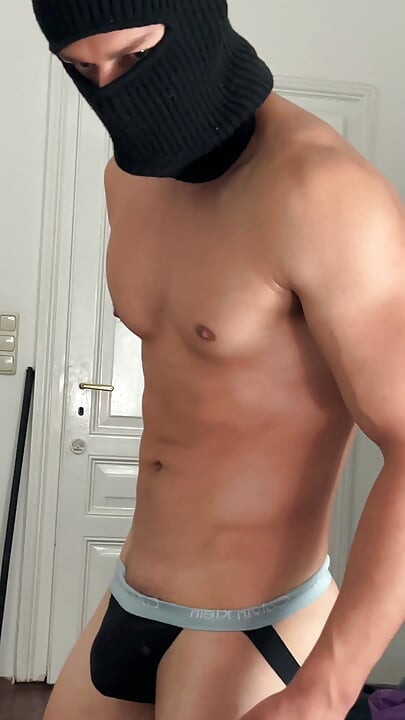 Young bodybuilder flexing his muscles in front of the mirror