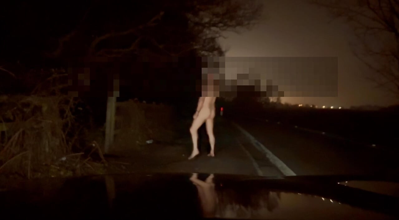 Crazy naked exhibition barefoot with cars passing close