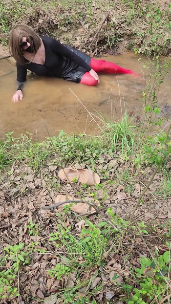 Must-see moment from "Crossdressed outdoors playing in a stream. Wearing pantyhose and miniskirt."