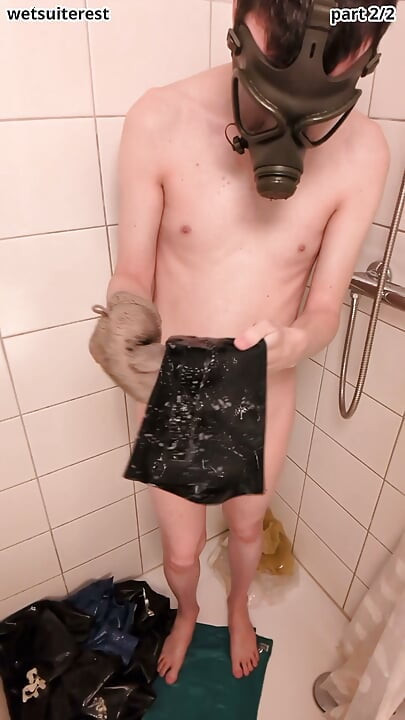 Latex laundry in shower wearing rubber gas mask