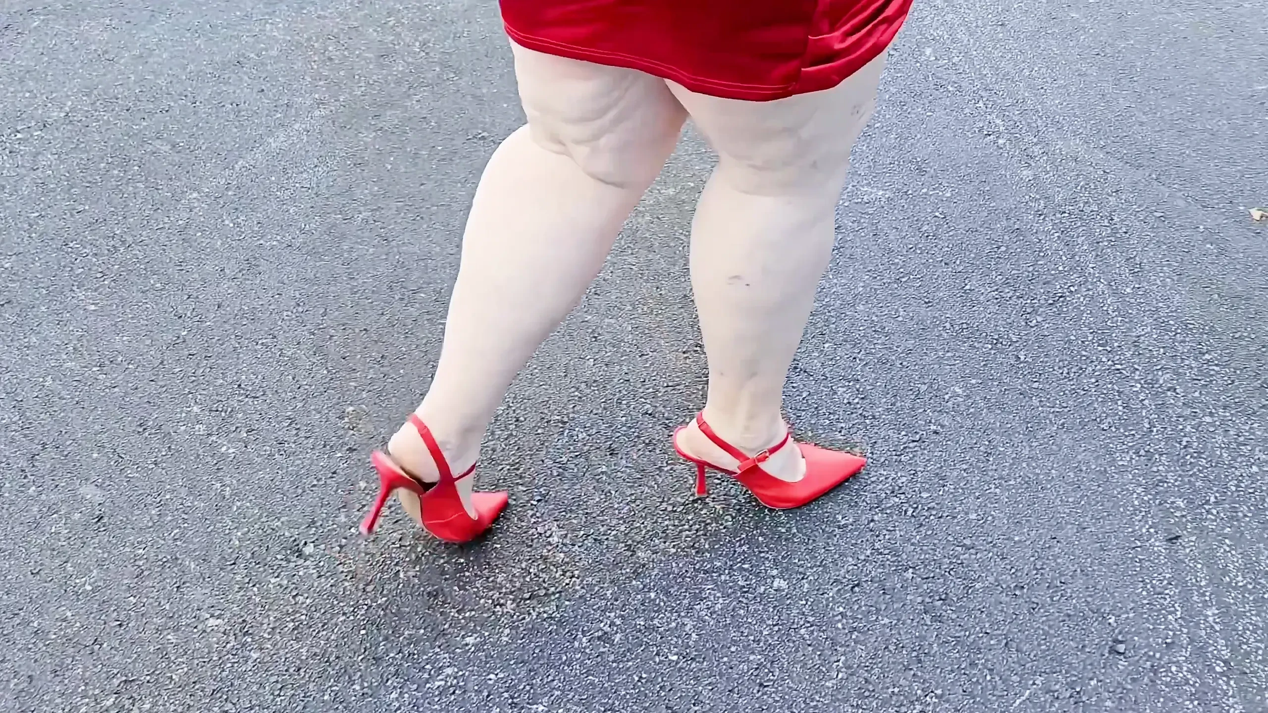 美丽的女人在公共停车场户外散步，为陌生人炫耀