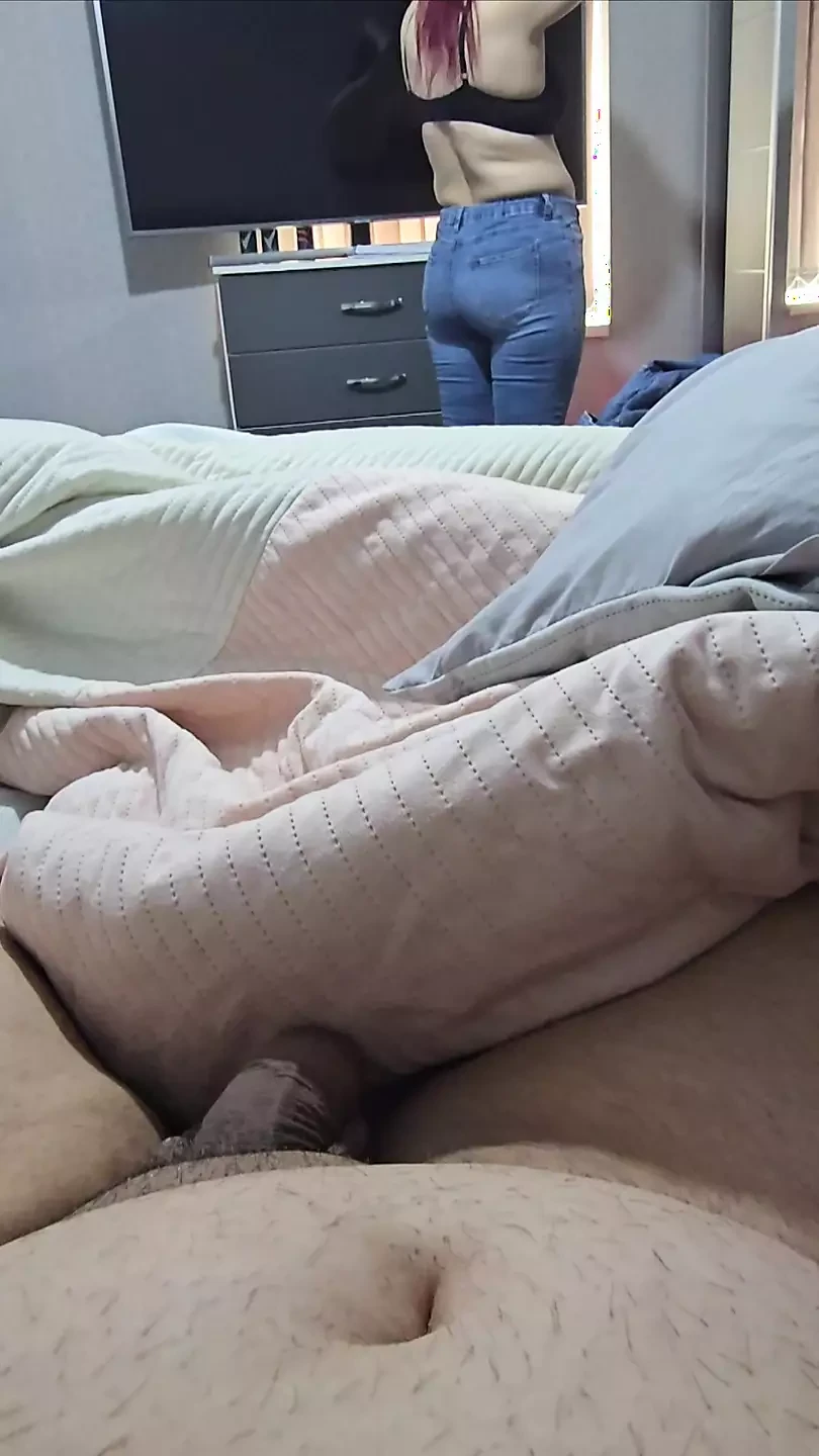 Une belle-mère en jean bleu essaye une nouvelle tenue devant son beau-fils nu